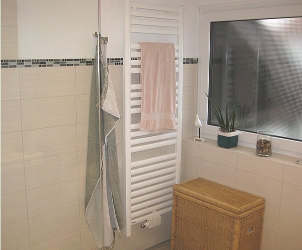 Fertiggestelltes Badezimmer mit Handtuchheizkörper und Spiegelschrank
