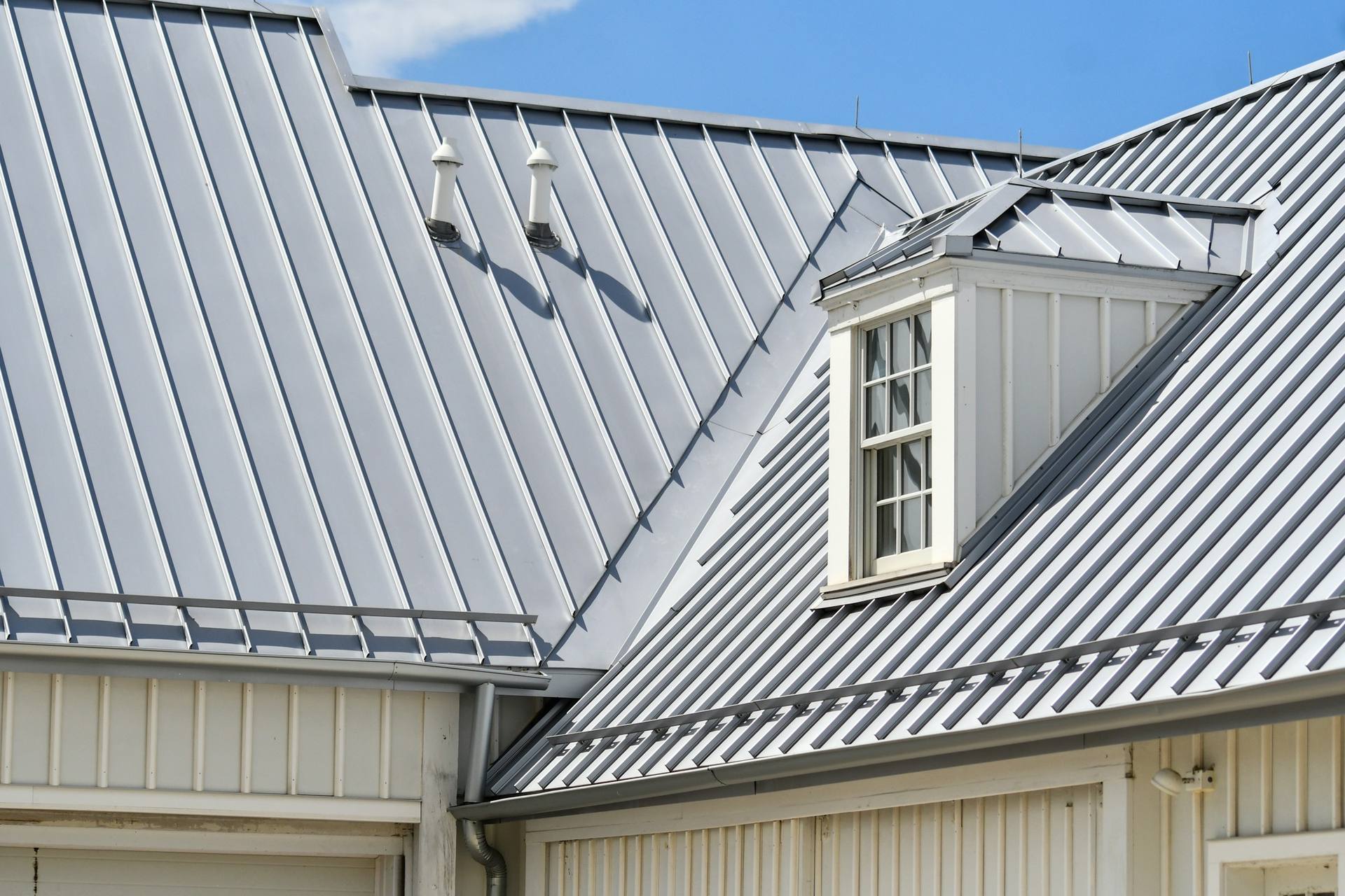 Metalldach mit Stehfalz und Gaube an einem Wohnhaus