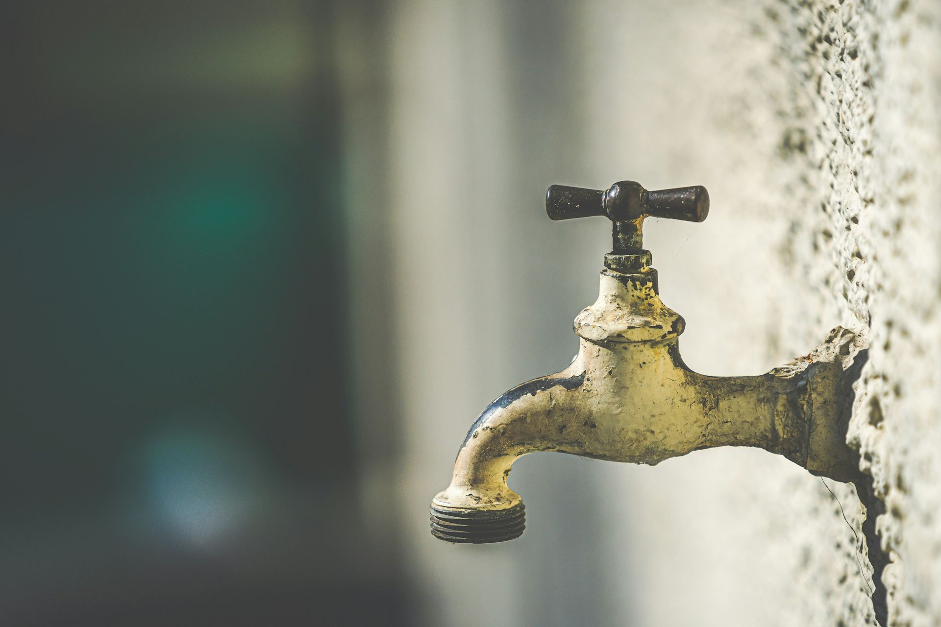 Messing-Wasserhahn an einer hellen Außenwand