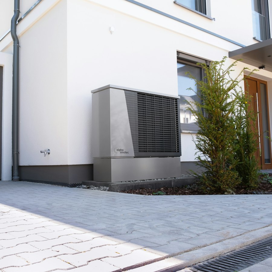 Modernes Wohnhaus mit Wärmepumpen-Außeneinheit im Vorgarten